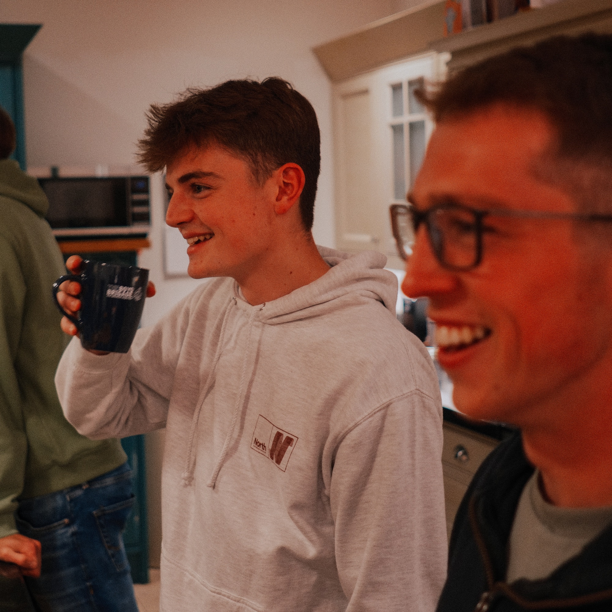 A home group gathered in a living room with open Bibles and mugs of tea